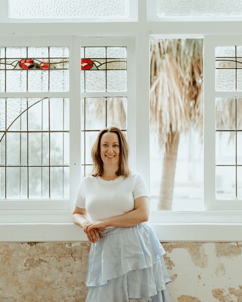 Karis Dorrigan standing at a leadlight window